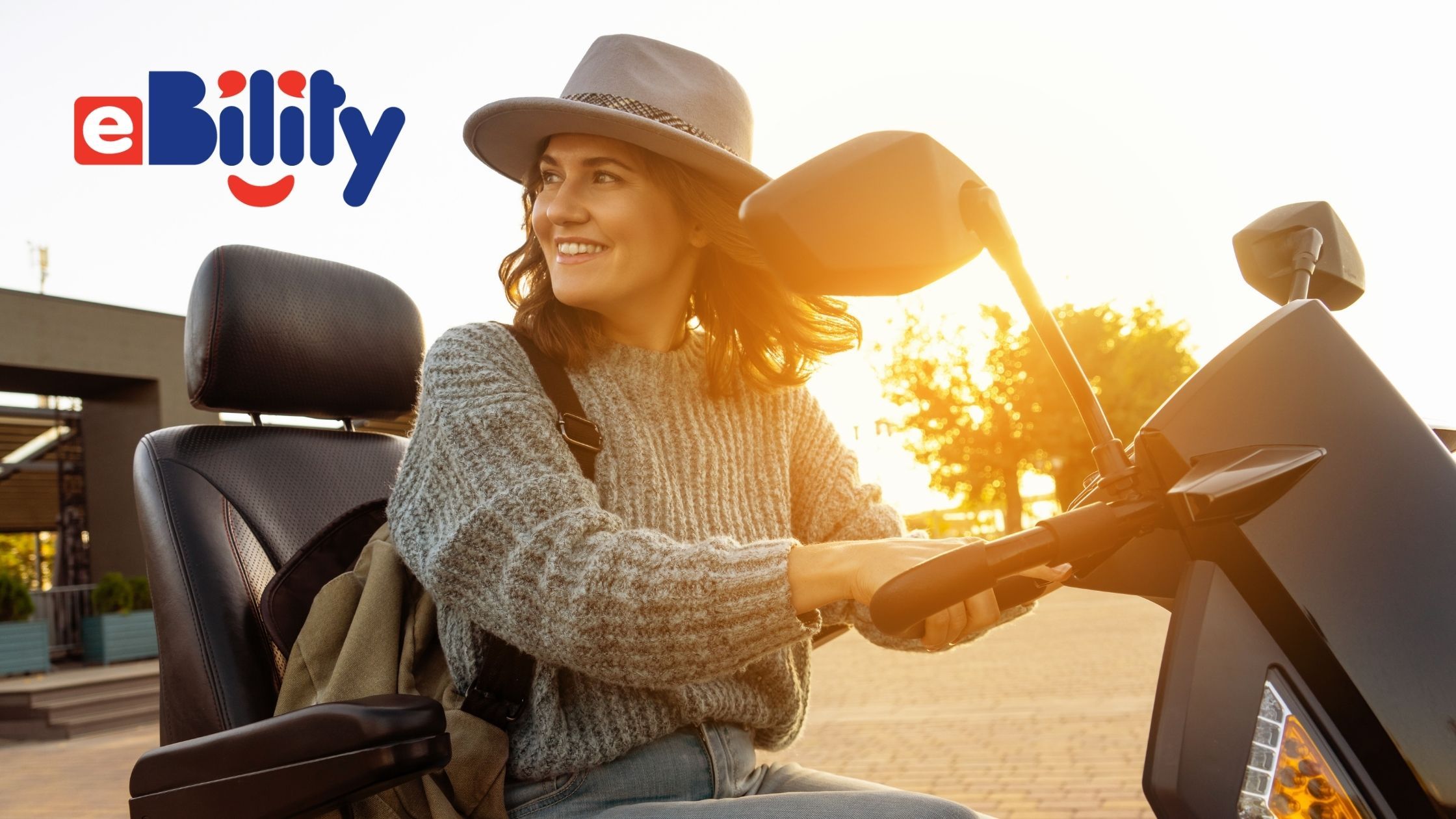 woman riding a mobility scooter with a wide-brimmed hat at sunset